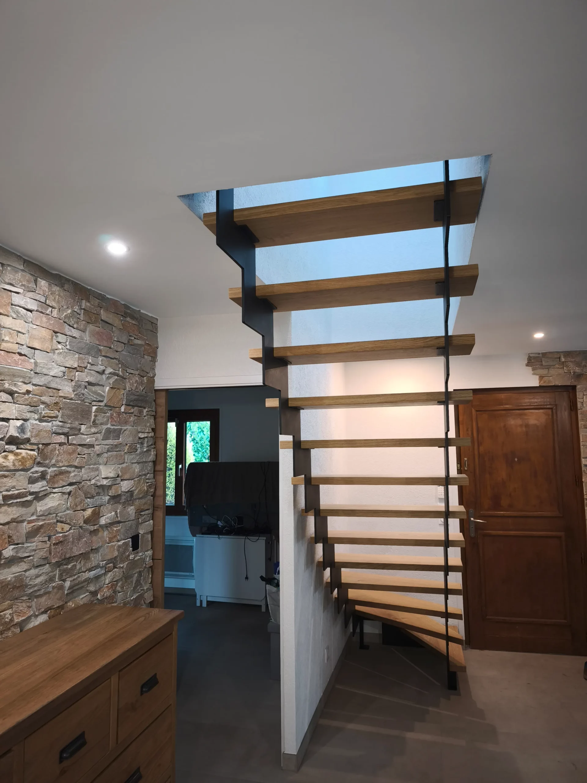 Détail d’un escalier balancé en acier et bois sur mesure