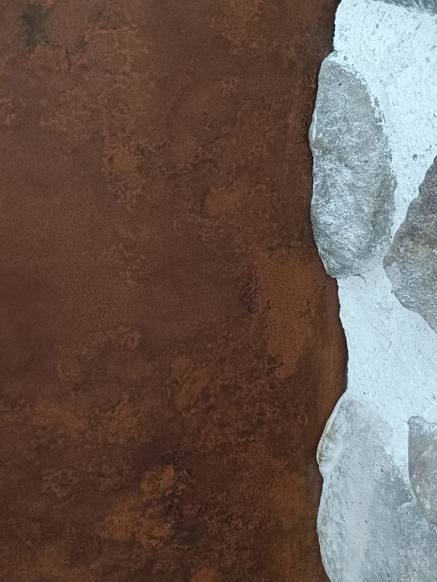 Détail de tôle en acier rouillé pour habillage de cheminée sur mesure.